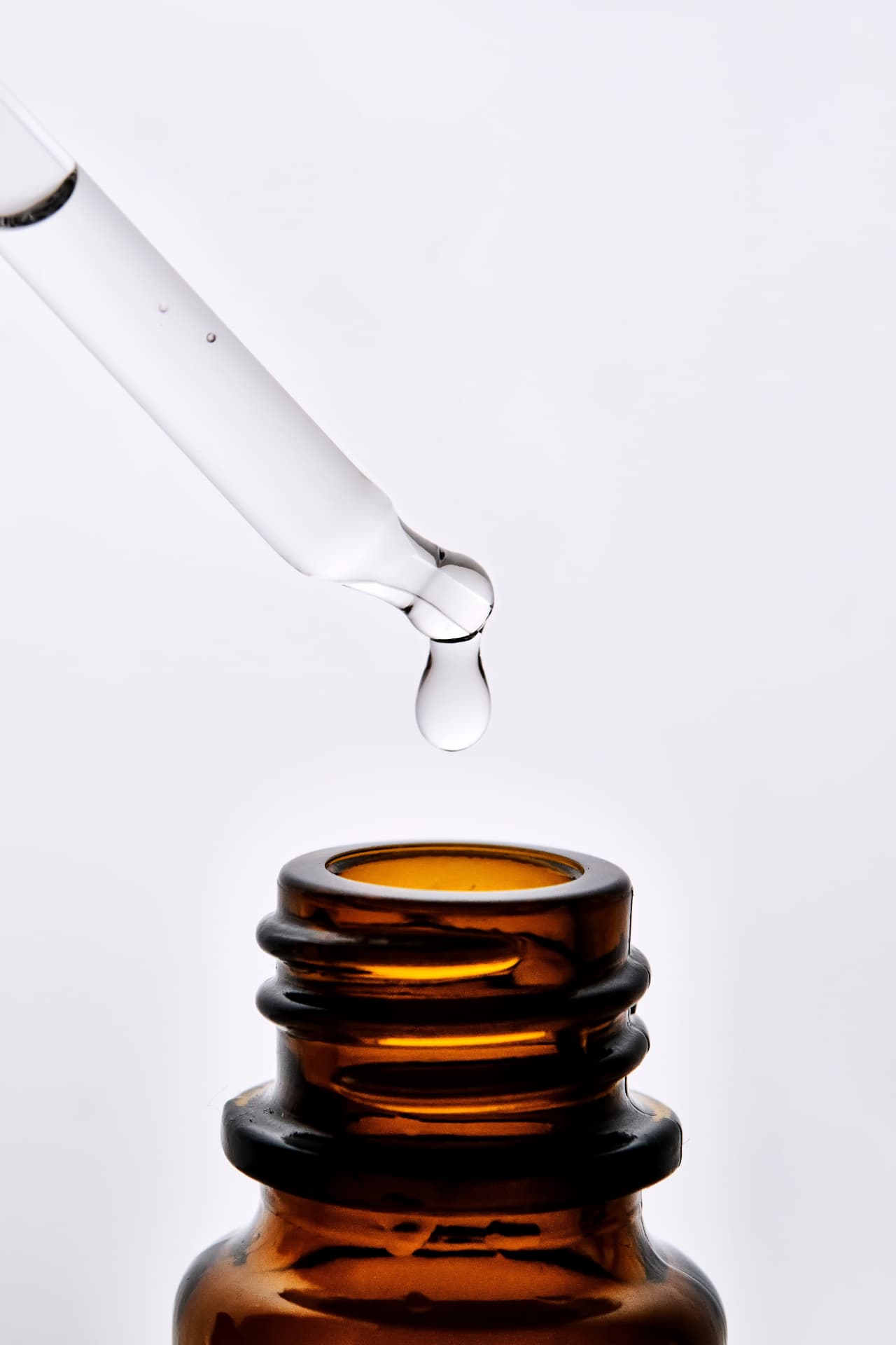 Amber dropper releasing a bead of serum