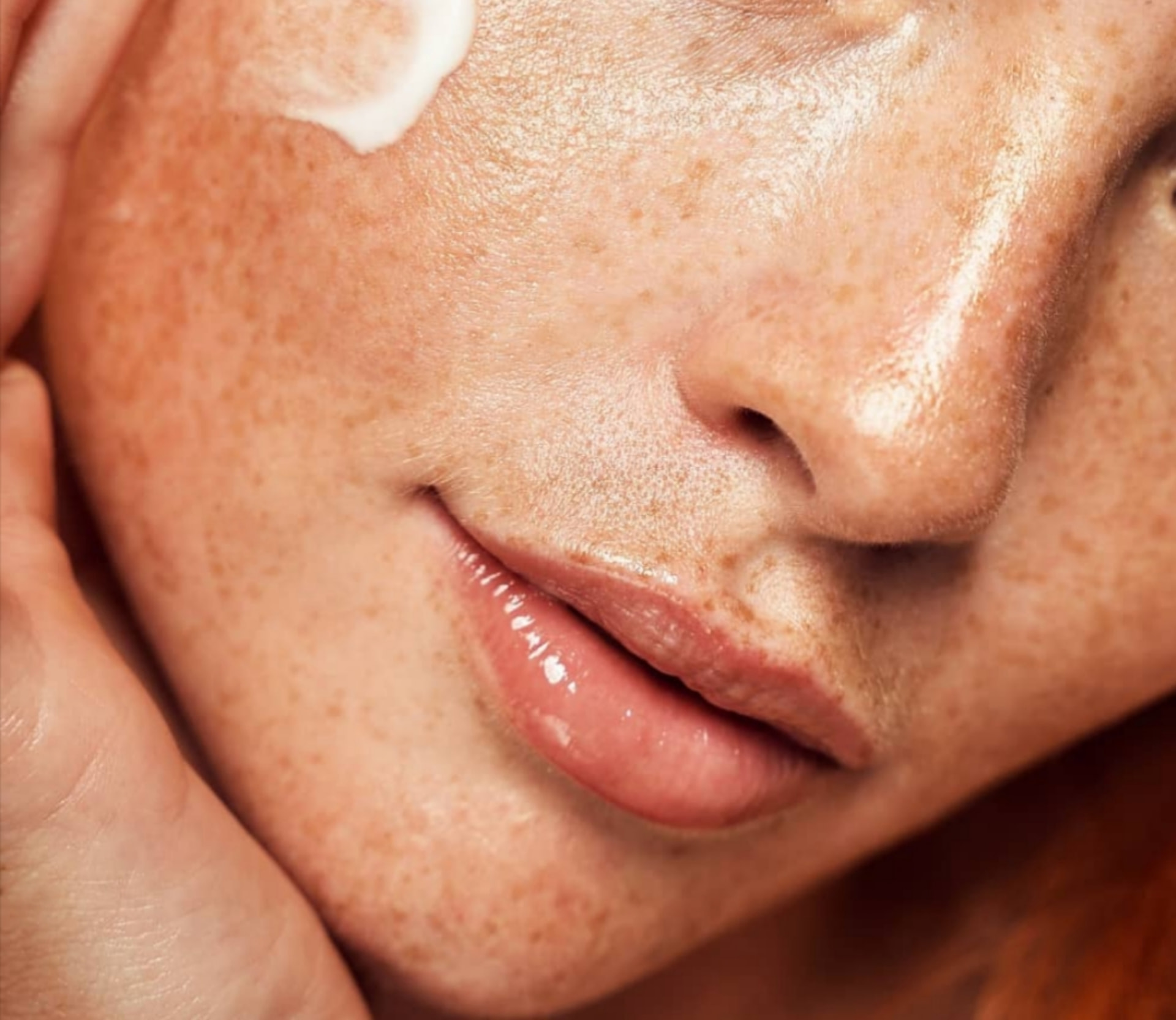 A dab of cream on freckled, healthy skin